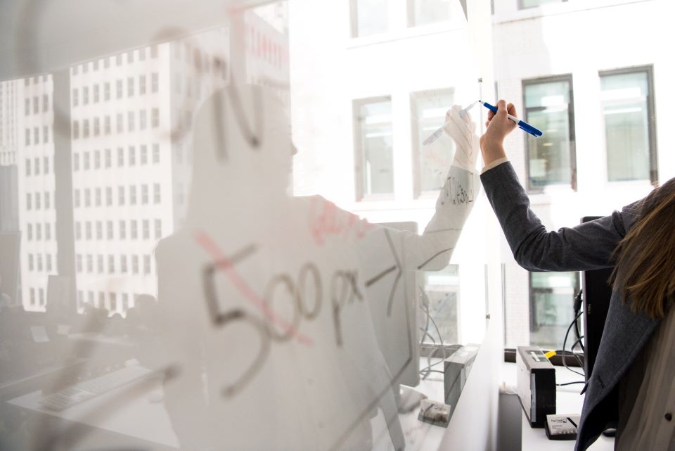 A person writing on white board